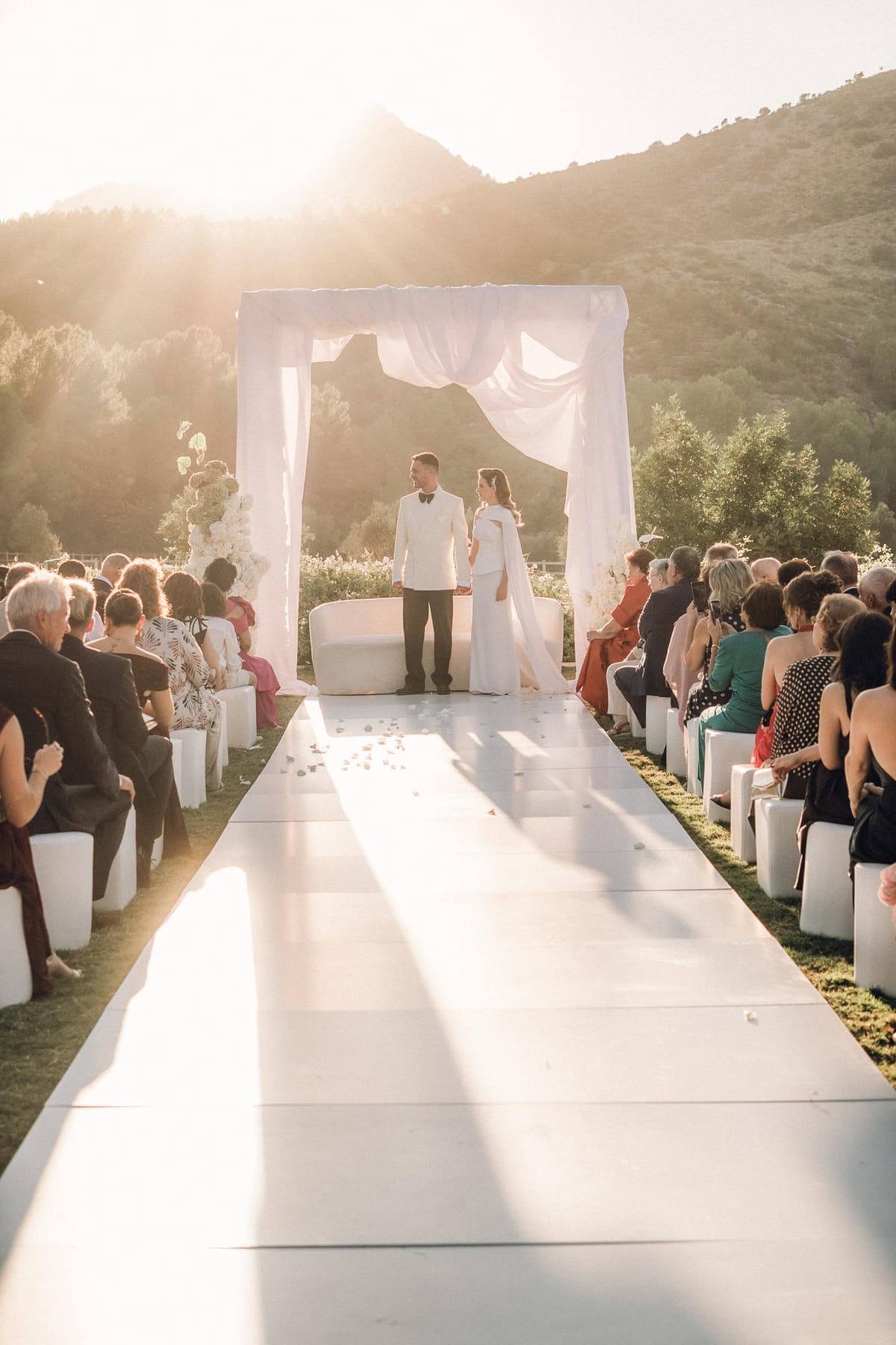 Ceremonia al atardecer: la pareja bajo el arco de tela con los invitados
