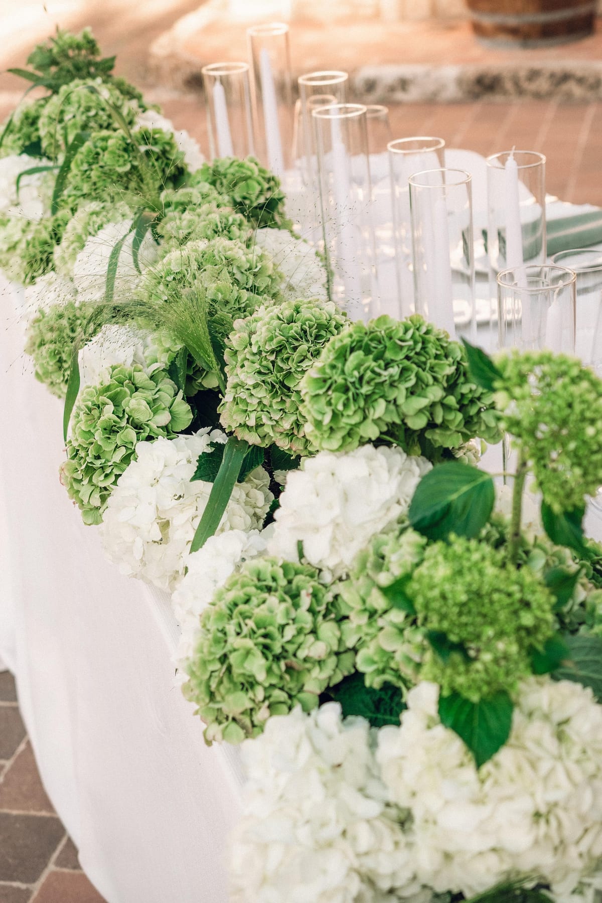 Centro de mesa con hortensias verdes y blancas y velas